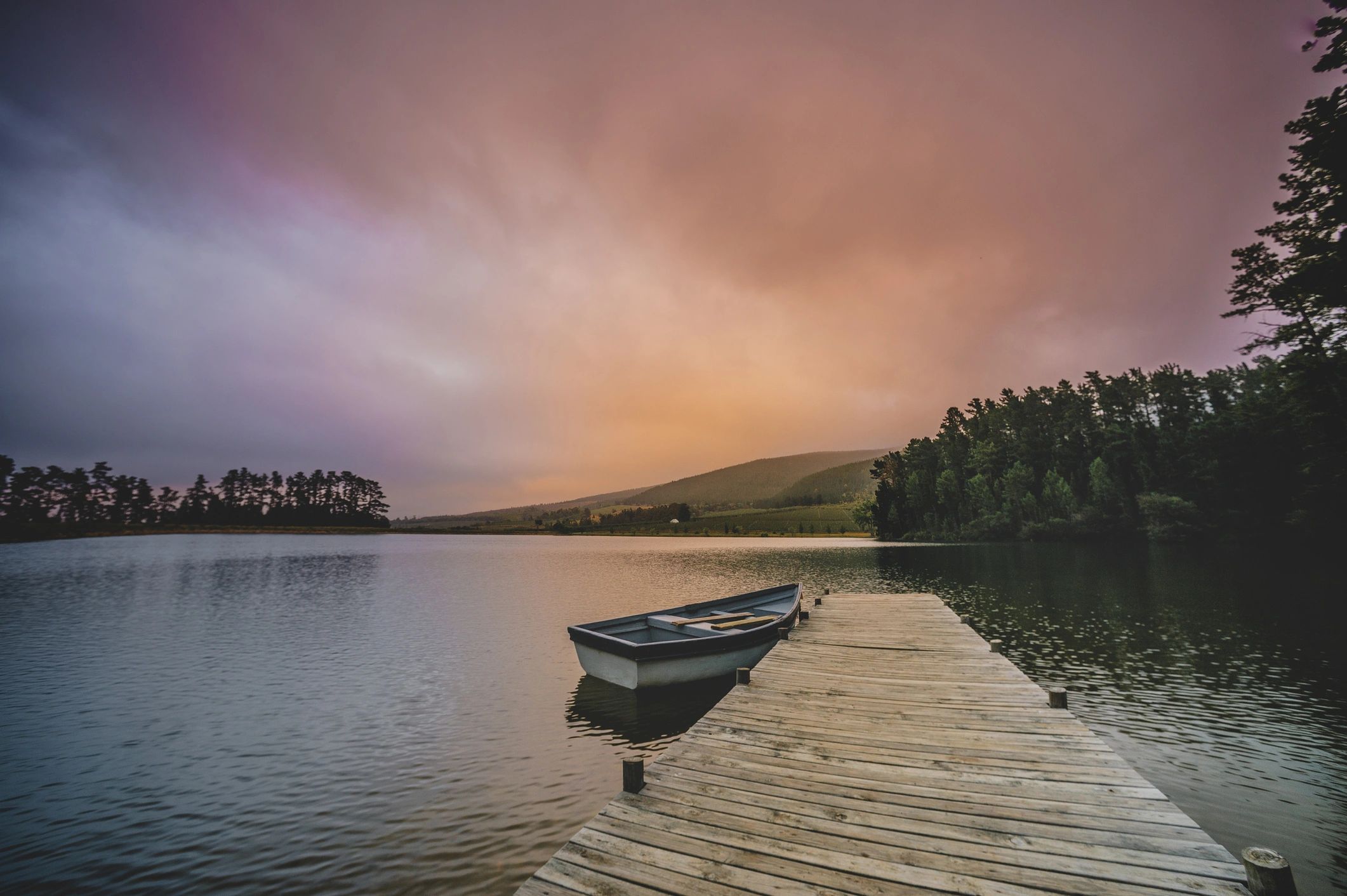 Moored rowboat beside a wooden jetty at dawn