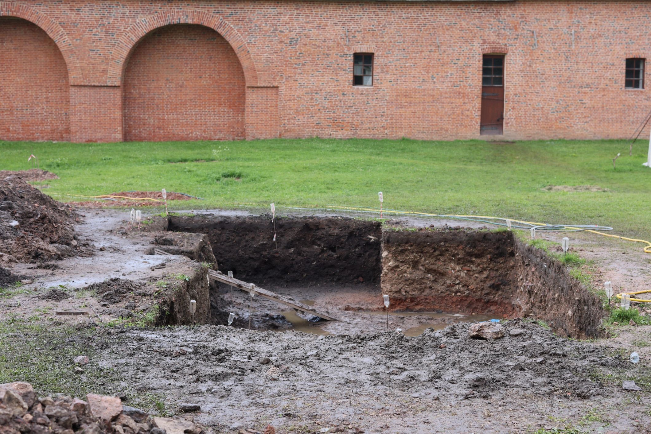 Archaeological excavation beside a historic brick building